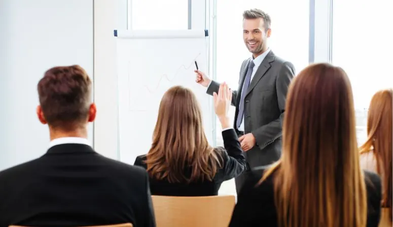 Instructor frente a un grupo de profesionales en una sesión de capacitación