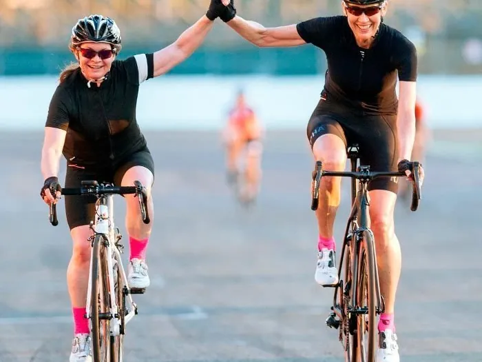 Dos ciclistas de ruta chocan las manos al llegar a la meta